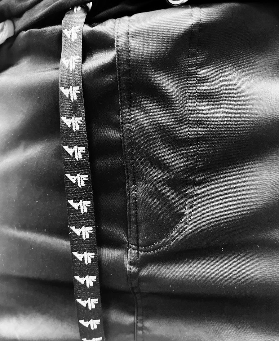 Pantaloni negri casual din material lucios cu buzunar laterale si capse de design
