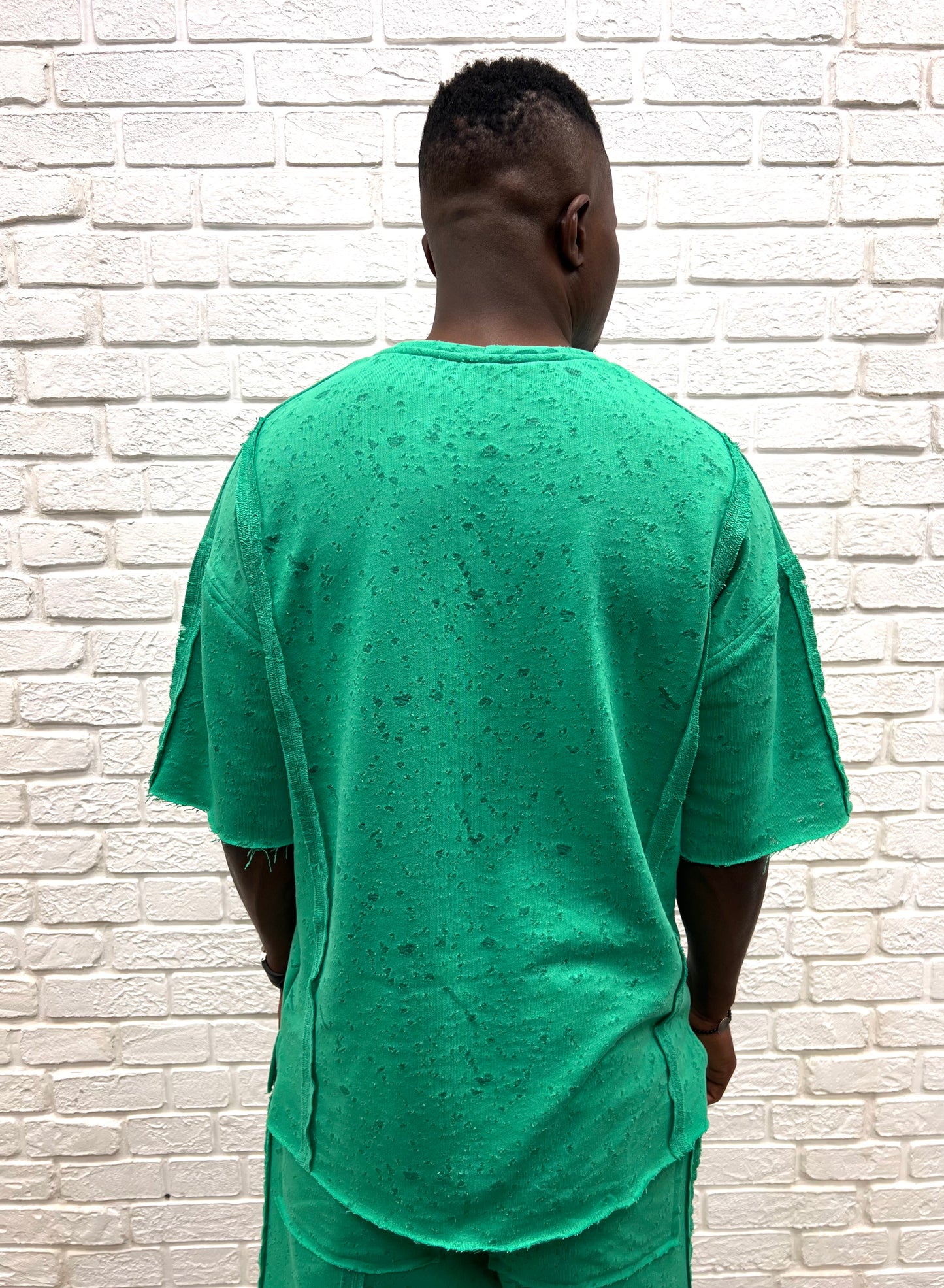 Tricou verde cu material perforat la suprafata ca design