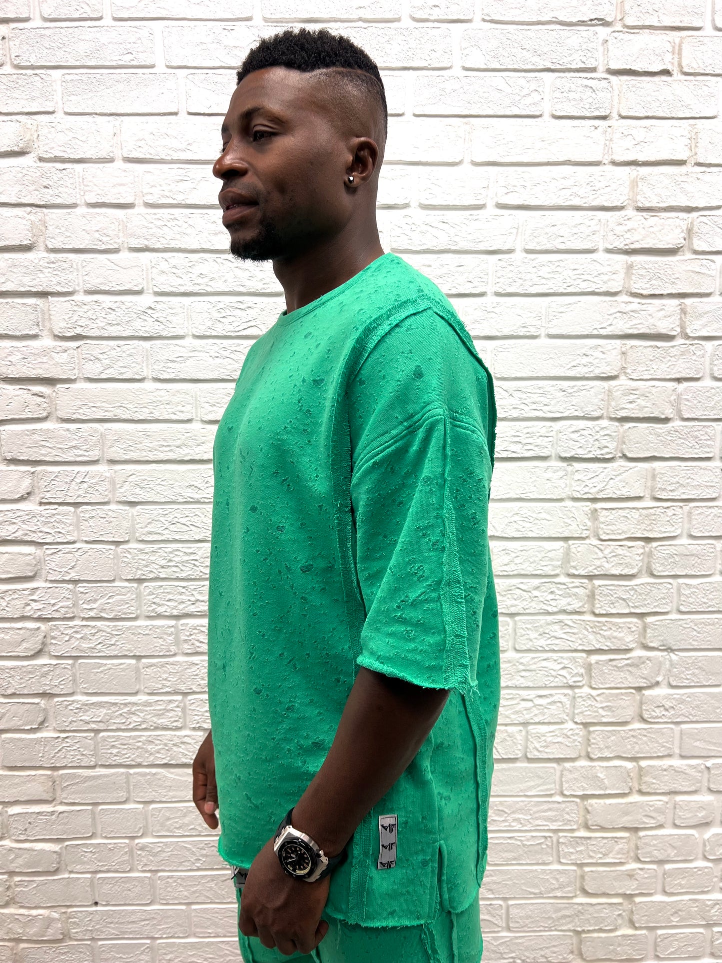 Tricou verde cu material perforat la suprafata ca design